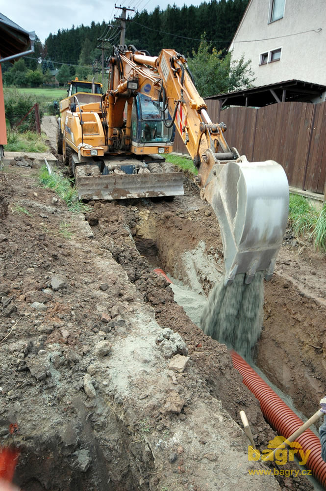 Kolové rypadlo Samsung SE130W-2 sdružení Zemní práce Kotlán obsypává kanalizaci