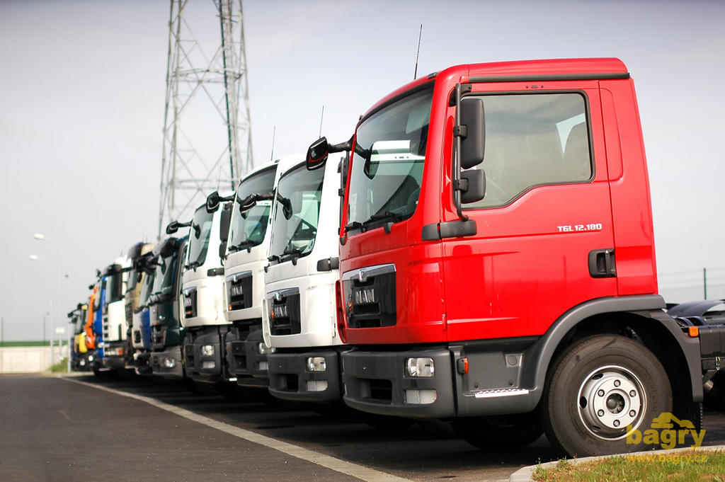 Úhledná řada vozidel čekající na své osazení nosičem kontejnerů